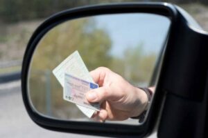 Conduite véhicules Licences Rétroviseur voiture Main présentant Permis de conduire et Carte grise de circulation