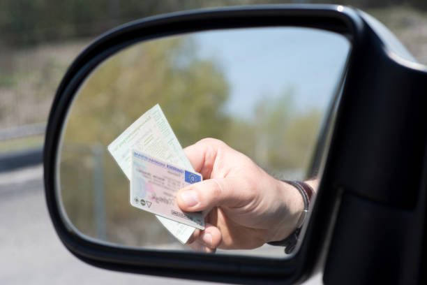 Conduite véhicules Licences Rétroviseur voiture Main présentant Permis de conduire et Carte grise de circulation